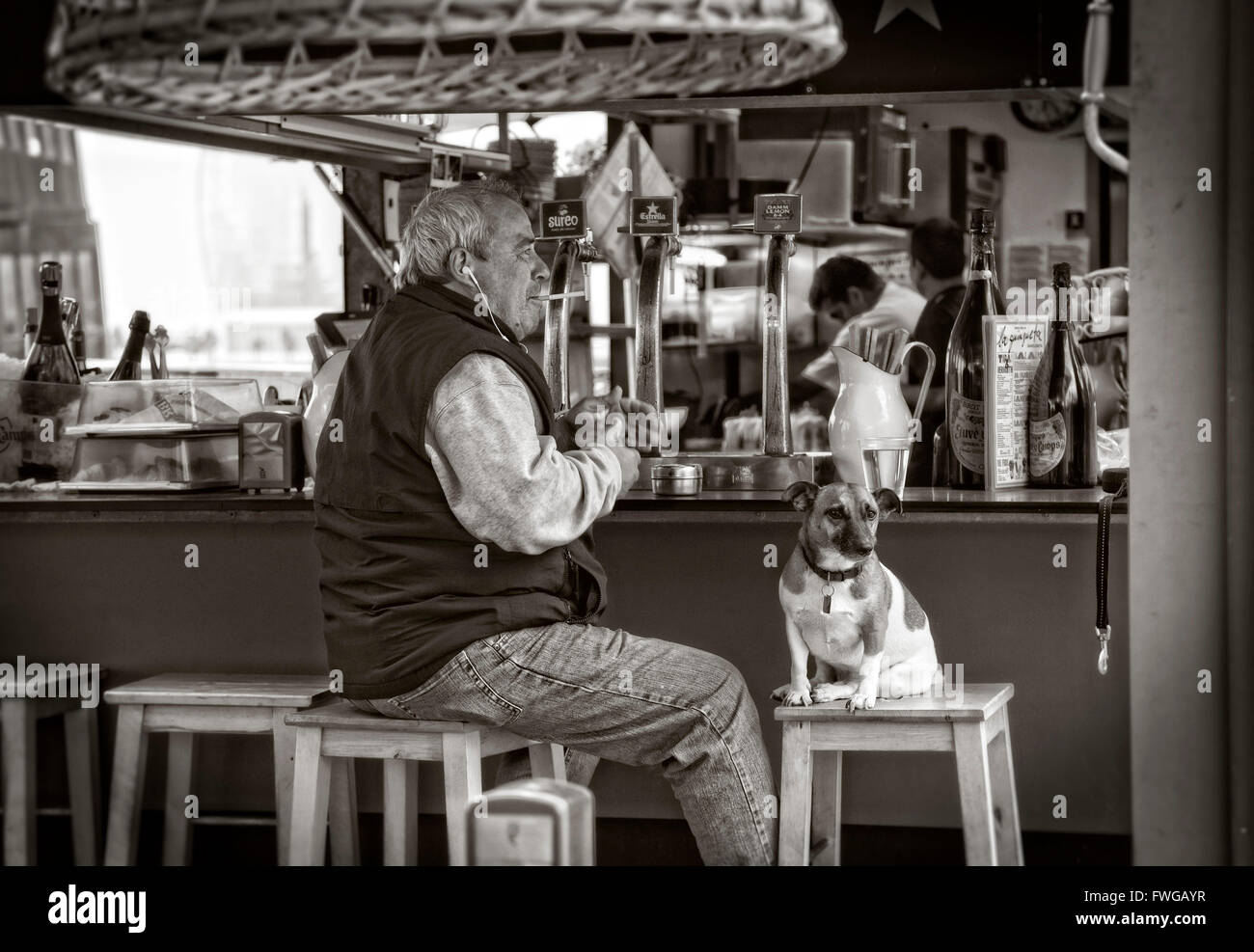 El hombre y su perro en el bar de la playa. Versión en color FT7YDY Foto de stock