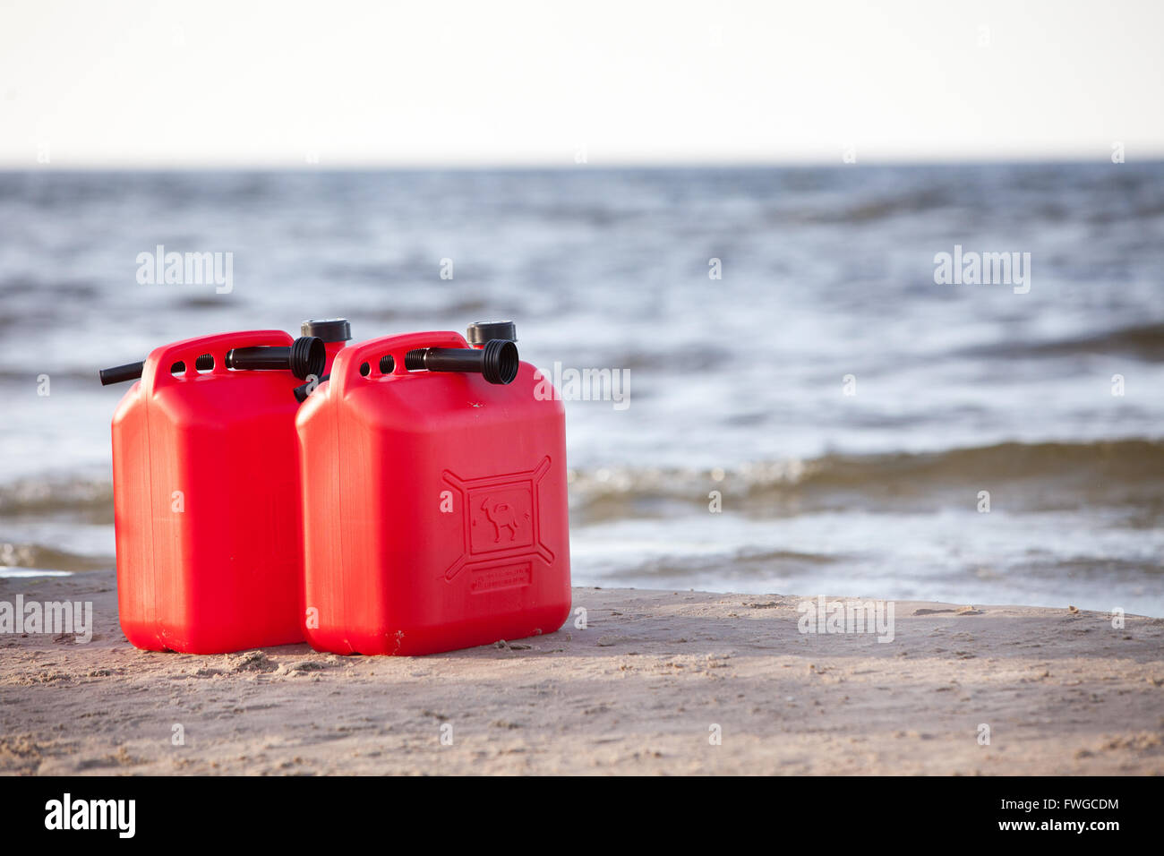 Dos latas de combustible rojo en la playa Foto de stock
