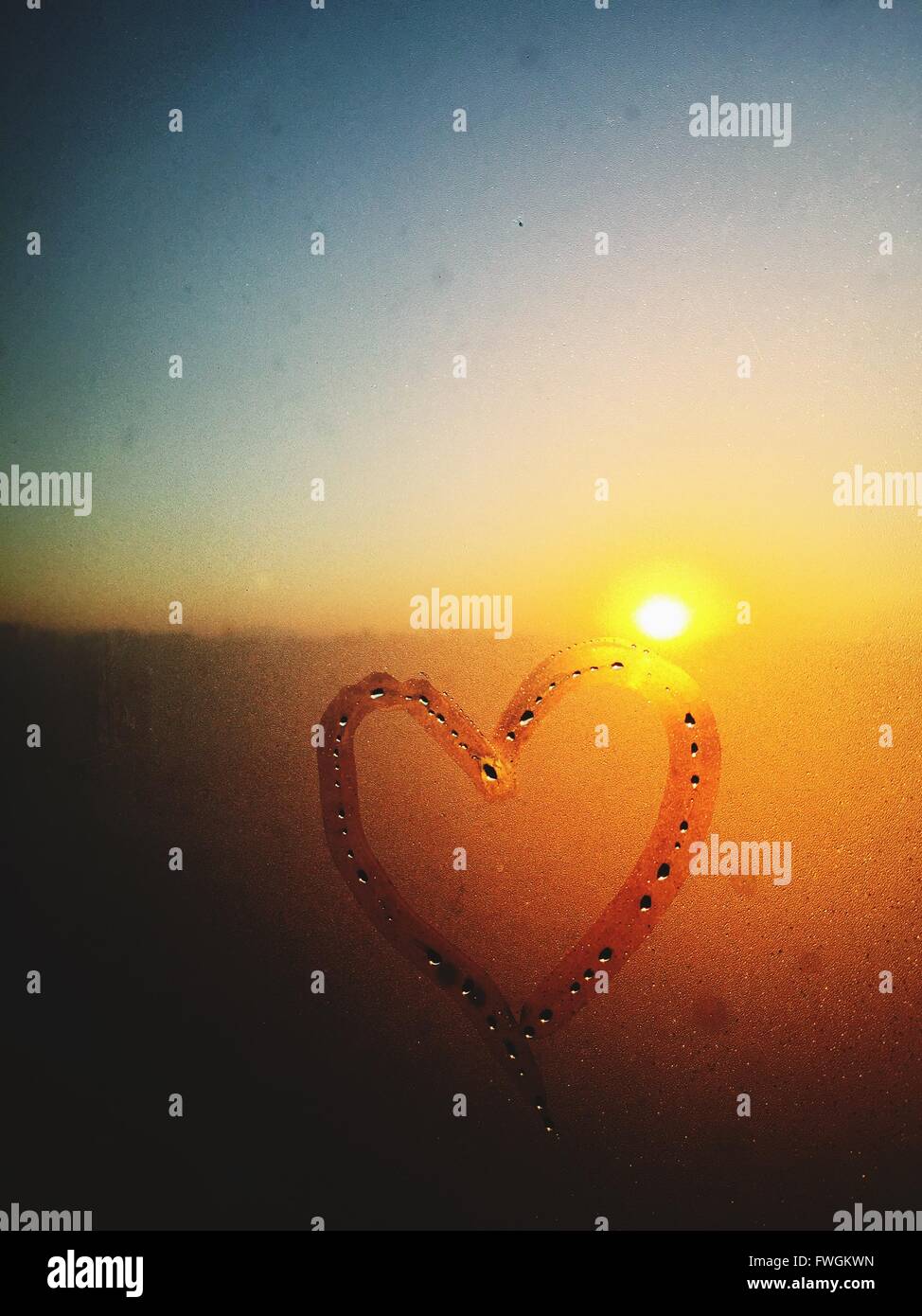 Corazón dibujado en la ventana condensada Foto de stock
