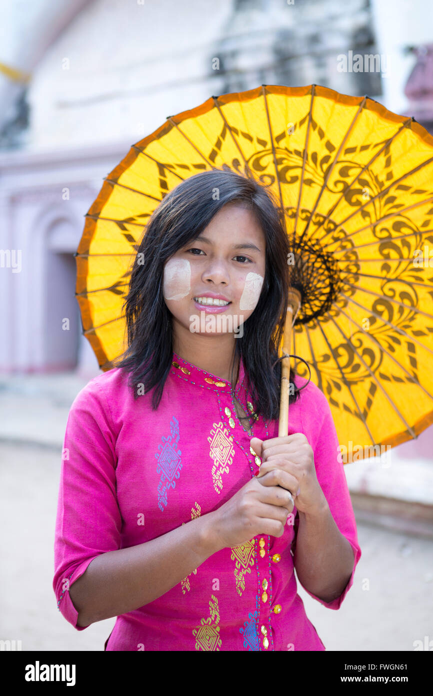 Una chica con un paraguas y sombrillas de papel tradicional thanaka pintura facial, Monywa, Sagaing, Myanmar (Birmania), el sudeste de Asia Foto de stock