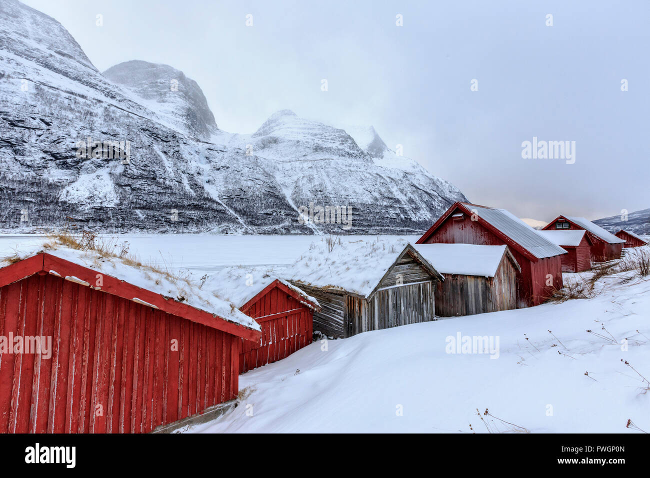 Cabañas de madera típicos en el paisaje nevado de Lyngseidet, Lyngen Alpes, Laponia Troms, Noruega, Escandinavia, Europa Foto de stock