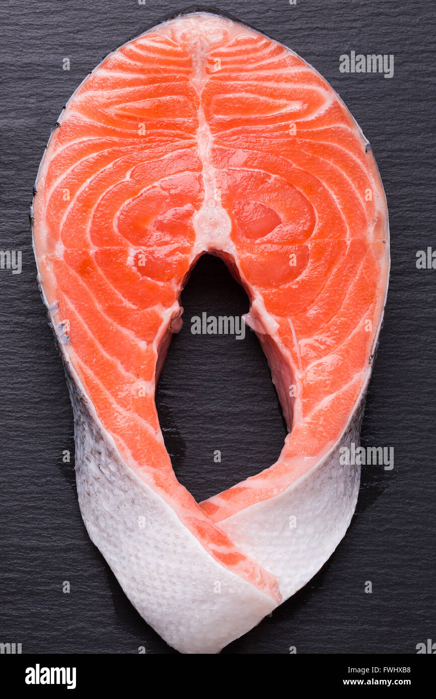 Filete de pescado rojo sobre una tabla de pizarra. Foto de stock