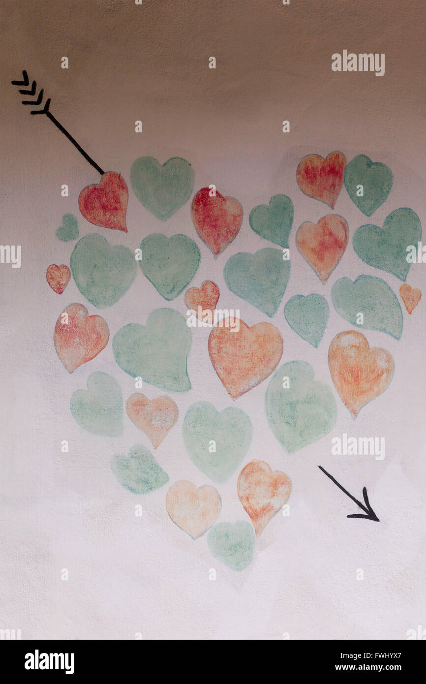 Pequeño y colorido corazón pintado en la pared, artesanía Foto de stock