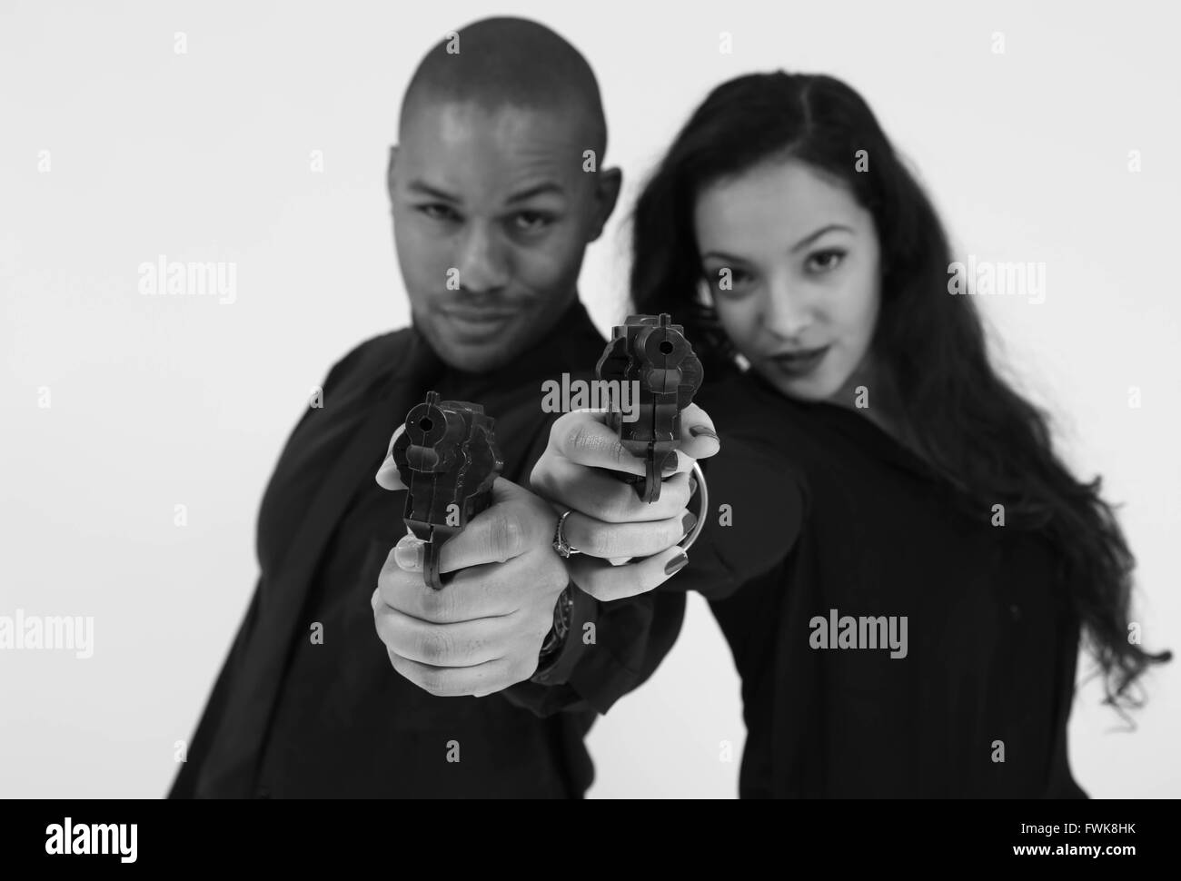 Retrato de moda Gangster amigos apuntando a la Cámara pistola contra el fondo blanco. Foto de stock