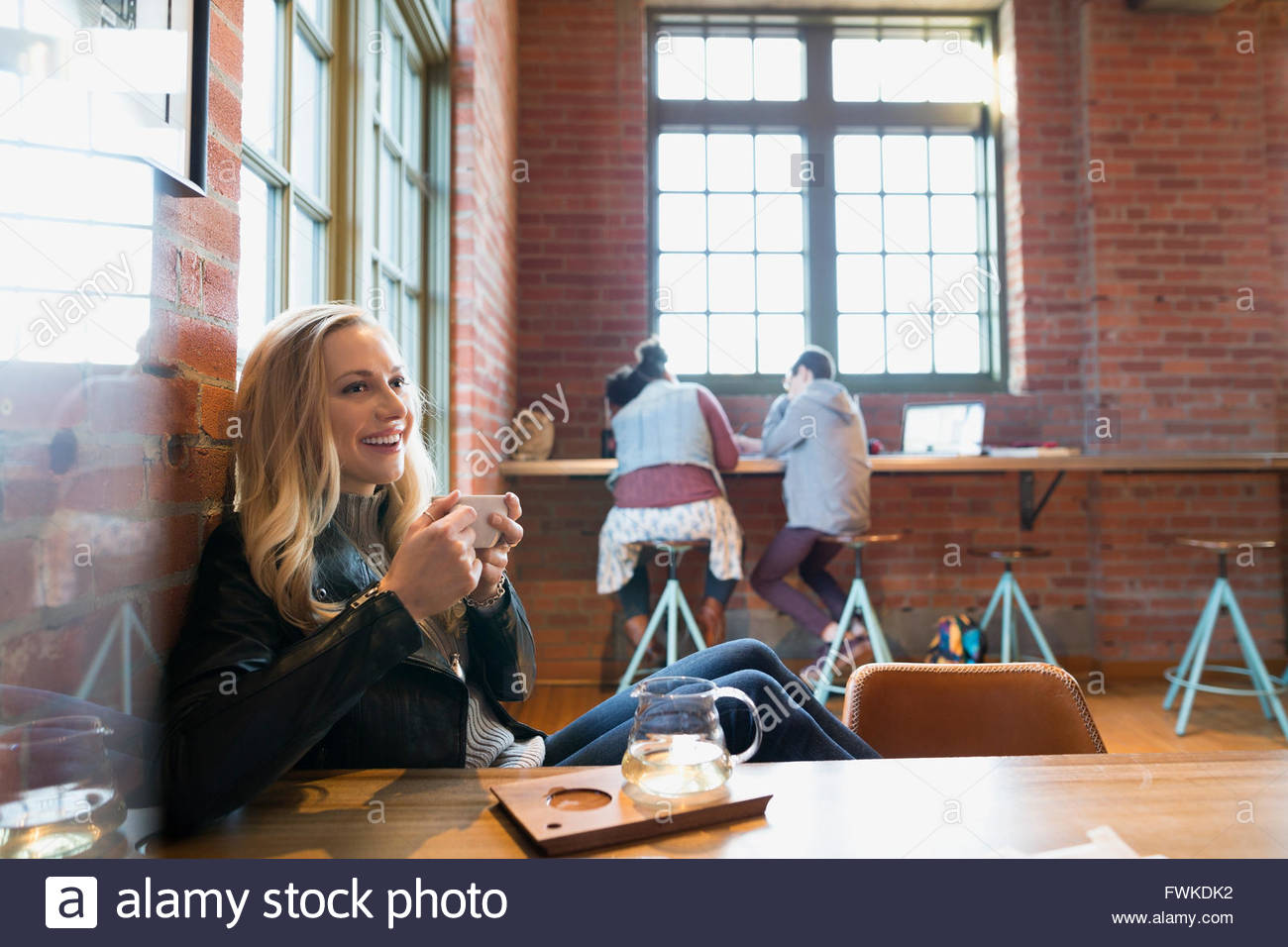 Mujer sonriente beber té en la cafetería. Foto de stock