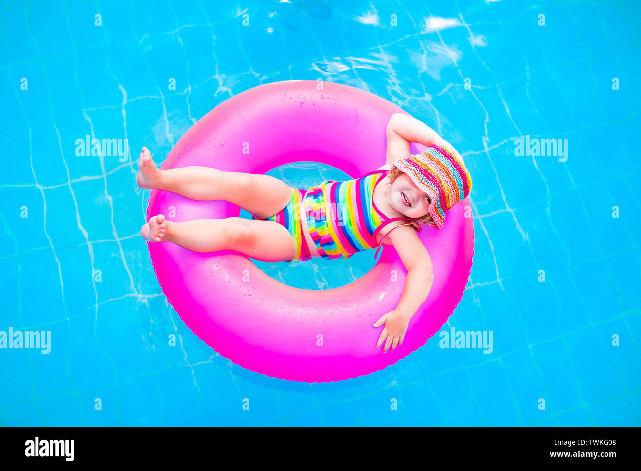 Lindo gracioso niño niña en un colorido traje de baño y gafas de sol  relajándose en un anillo de juguete inflable en una piscina flotante  Fotografía de stock - Alamy