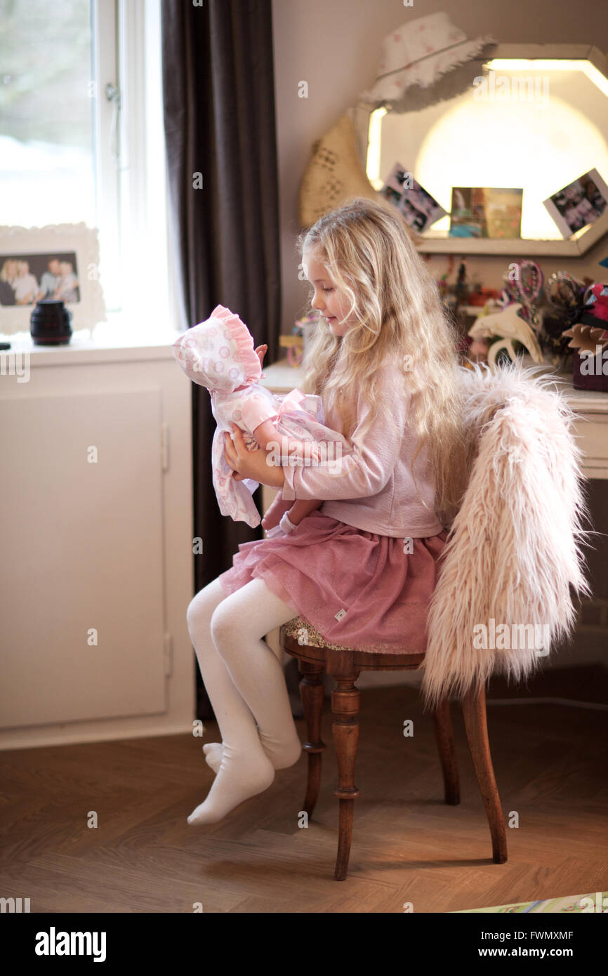 Niña jugando con su muñeca. La guardería, cabrito, sala de juegos, juego de aparentar. Foto de stock