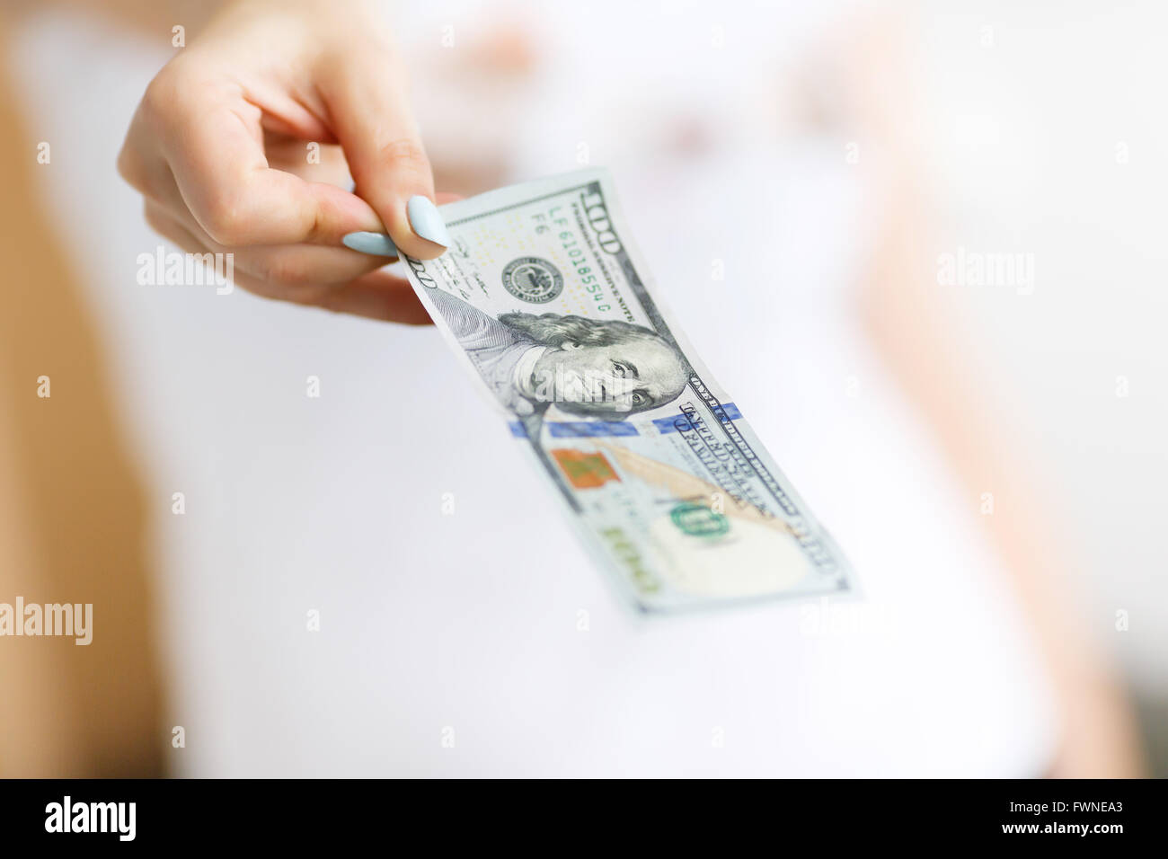 Mano de mujer dando dinero sobre el fondo blanco. Foto de stock