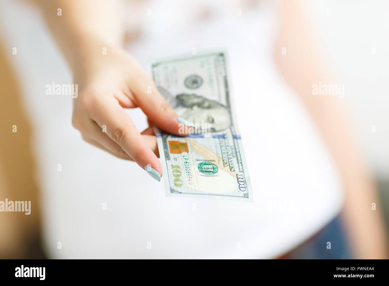 Mano de mujer dando dinero sobre el fondo blanco. Foto de stock