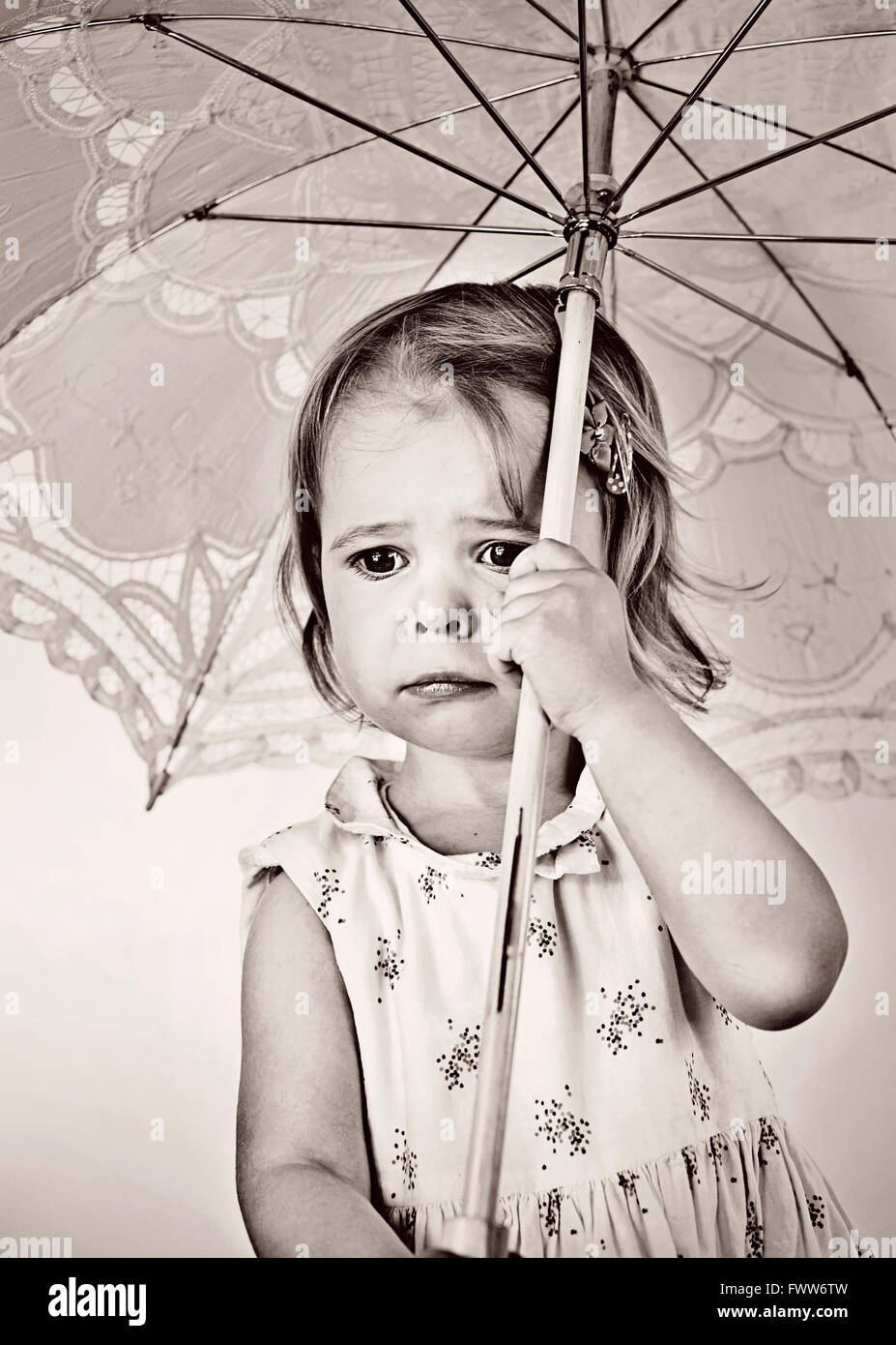 Pequeña niña llorando sosteniendo paraguas Foto de stock