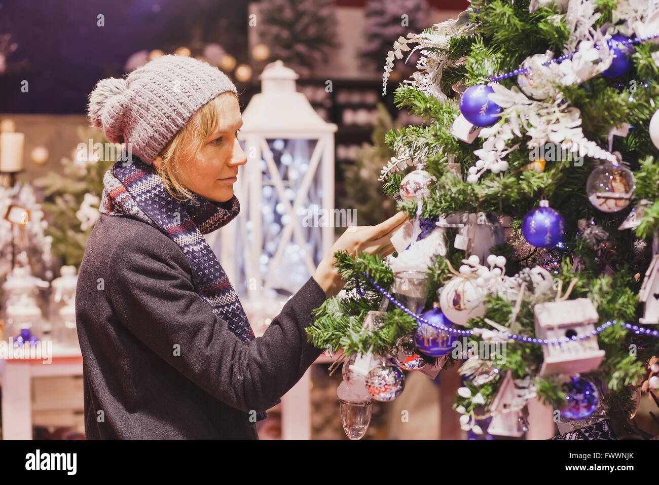 Las personas en el mercado de navidad, mujer elegir en la tienda de decoración navideña Foto de stock