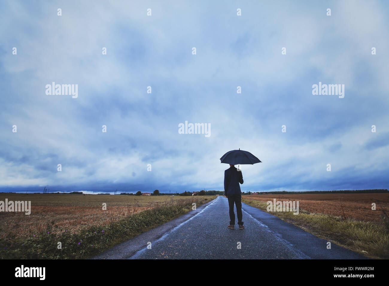 Concepto de psicología, el hombre con sombrilla de pie en el camino, los temores y la soledad Foto de stock