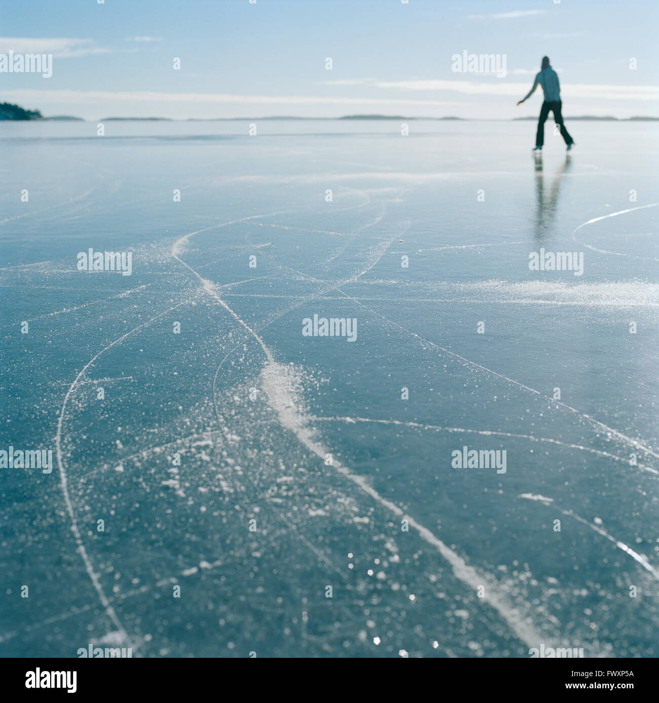 Suecia, archipiélago de Estocolmo, Uppland Varmdo, mitad mujer adulta Bjorno, patinaje sobre hielo en el lago congelado Foto de stock