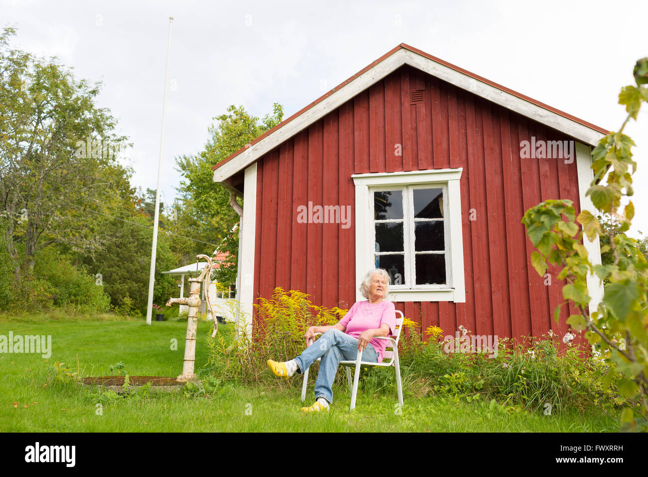Suecia, Ostergotland, Finspang, mujer Senior en la silla relajante al aire libre Foto de stock