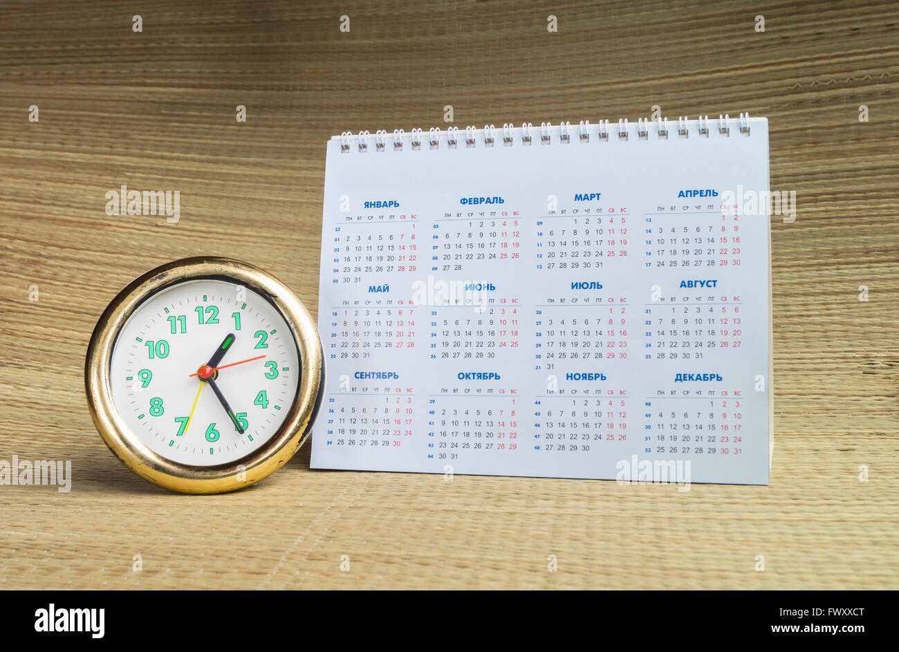 Ronda reloj con calendario de papel de escritorio sobre fondo beige  Fotografía de stock - Alamy