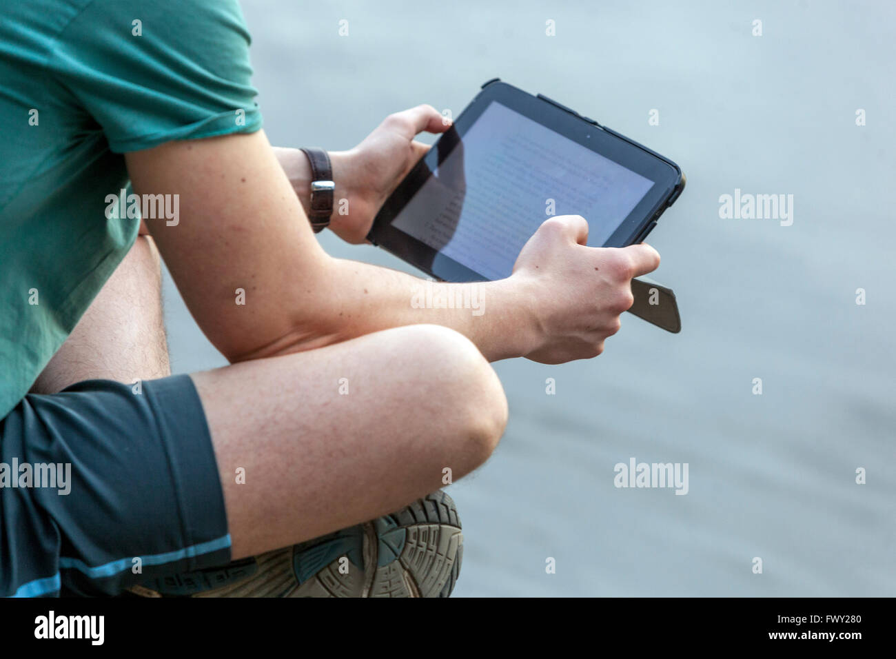Hombre mirando un tablet digital fuera de la vista posterior, modernos dispositivos digitales Foto de stock