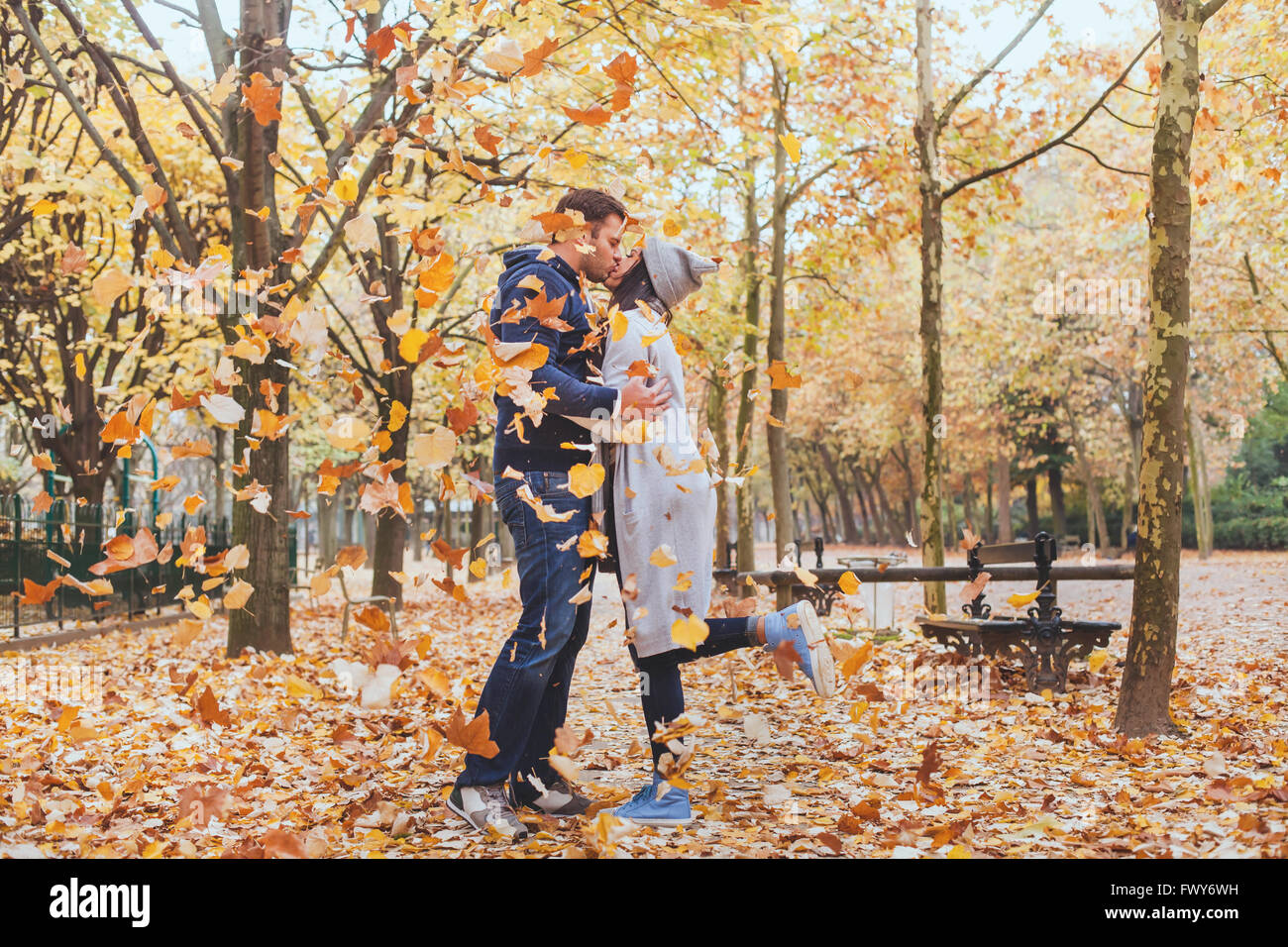 Beso de otoño, la joven pareja amorosa en el parque con la caída de las hojas Foto de stock