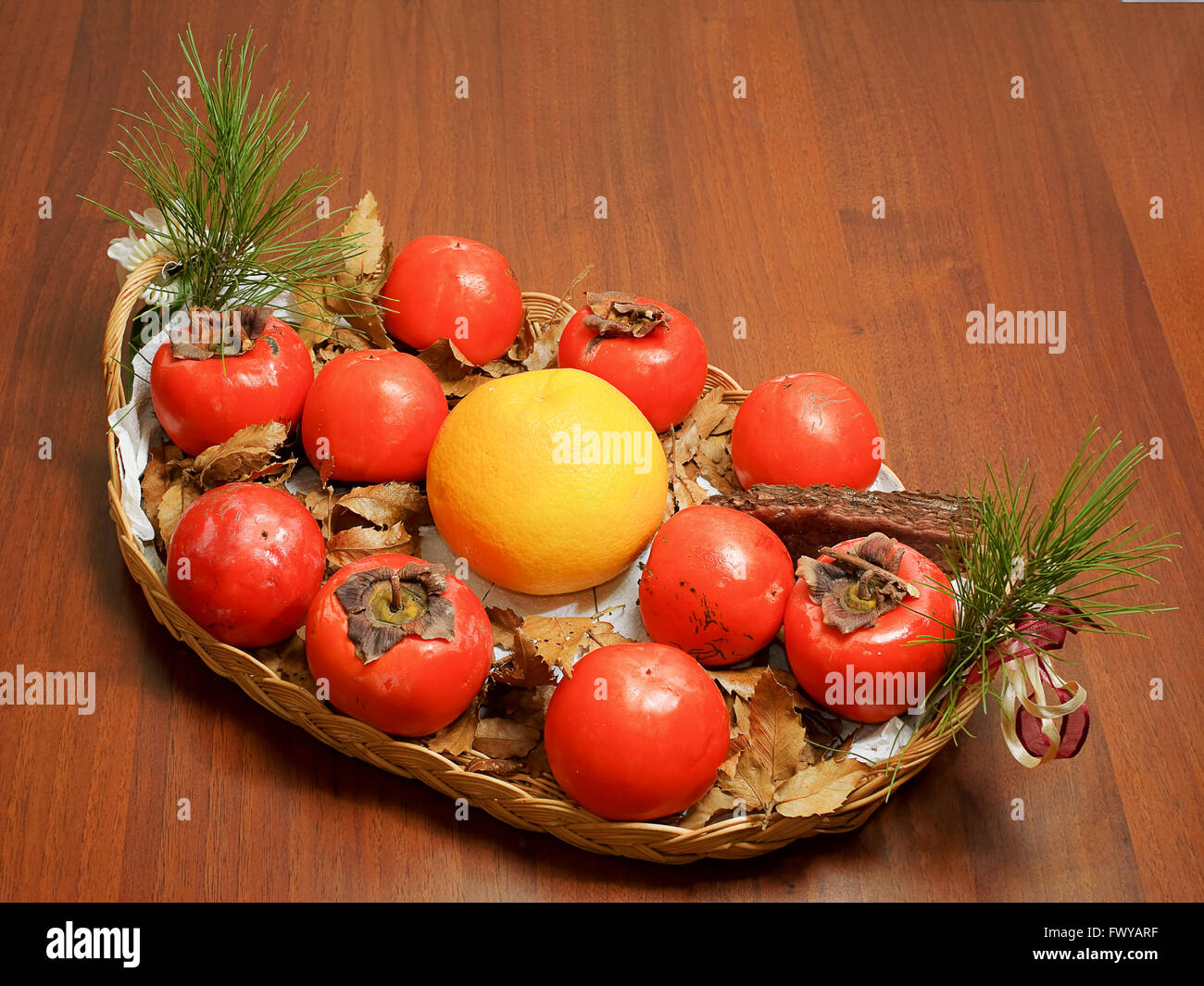 Composición de caqui, toronja y piña en el plato en la mesa Foto de stock