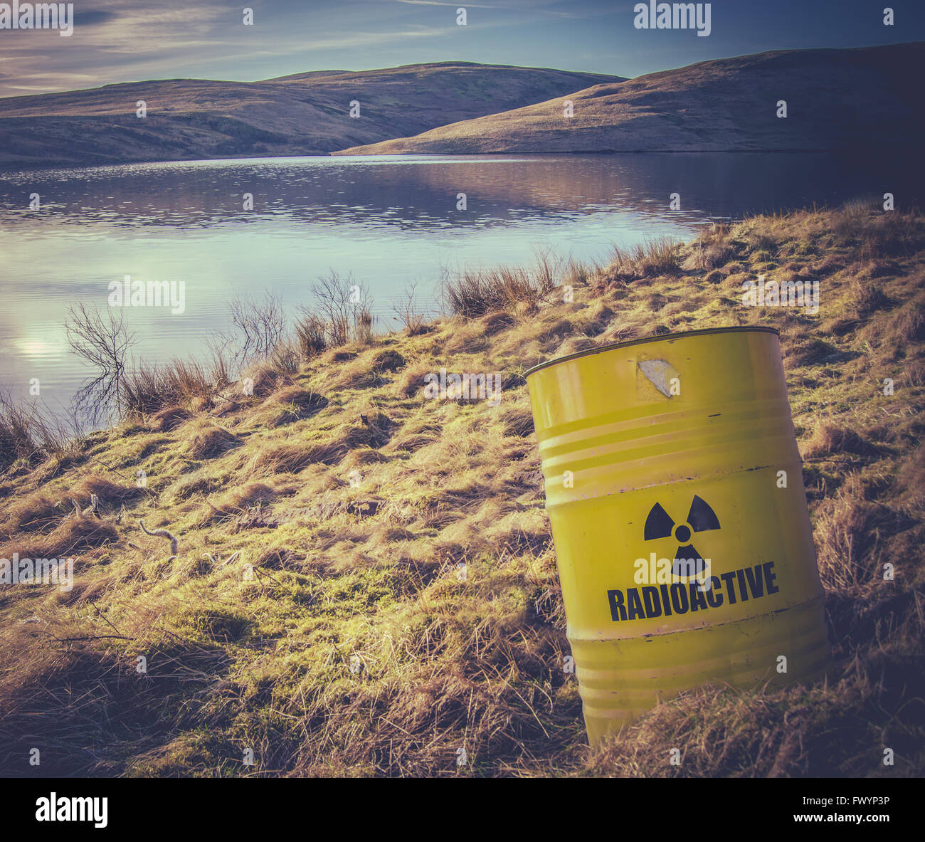 Barril de desechos nucleares radiactivos cerca del agua Foto de stock