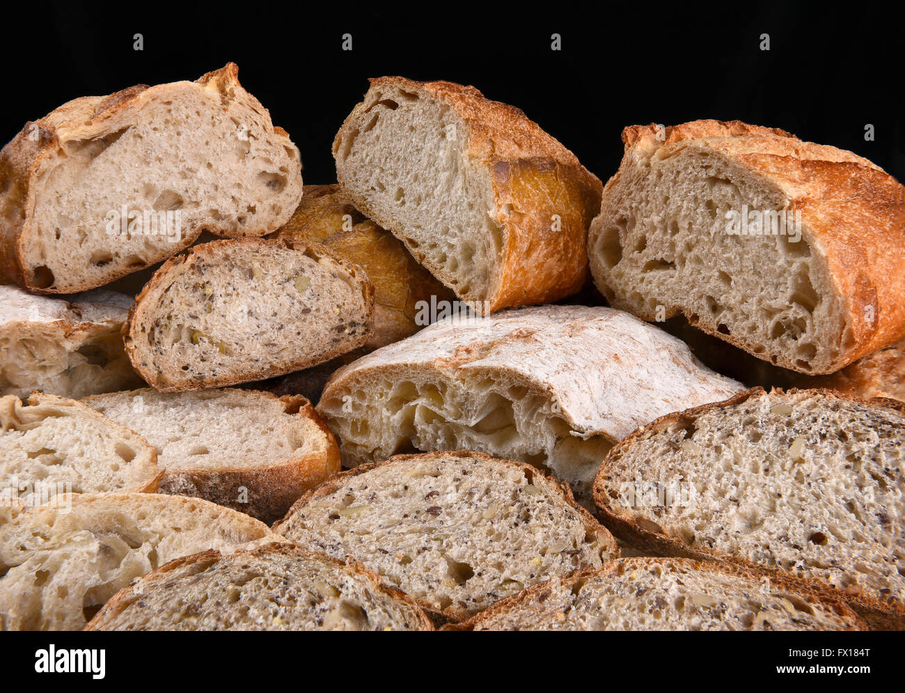 Una gran variedad de panes recién horneados, los panes se cortan por la mitad y en rodajas. Foto de stock