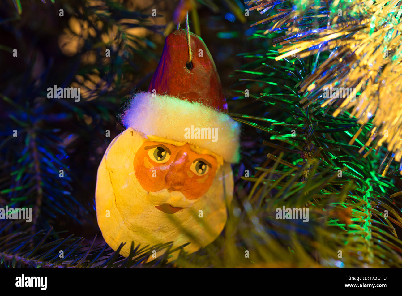 Ornamento del árbol de navidad de Santa Claus rostro iluminado por las luces del árbol de Navidad. Foto de stock