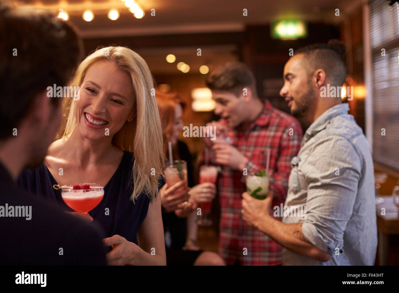 Un grupo de amigos, la reunión para tomar bebidas por la tarde en el Cocktail Bar Foto de stock