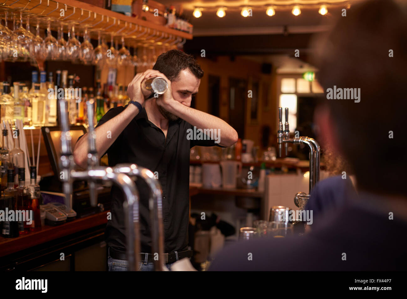 Barman haciendo cóctel en la barra utilizando Shaker Foto de stock