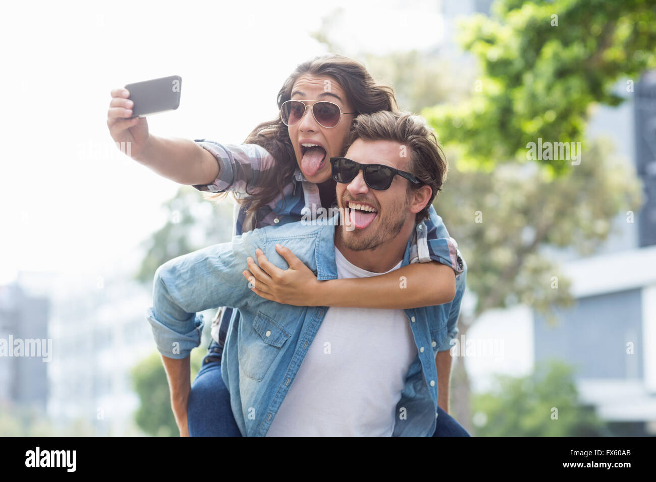 El hombre da a la mujer piggyback Foto de stock