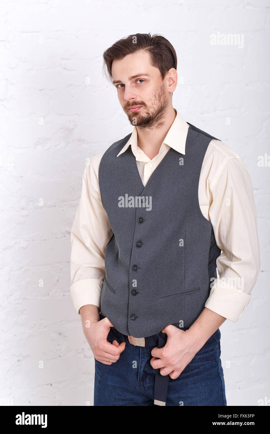 Joven Hombre con un y pantalones vaqueros. La moda masculina. El hombre puso sus manos sobre la correa. parece grave Fotografía de stock - Alamy