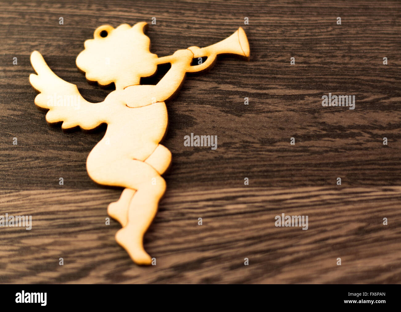 Angel con alas y trompeta, aislado sobre fondo de madera, Cupido Fotografía  de stock - Alamy