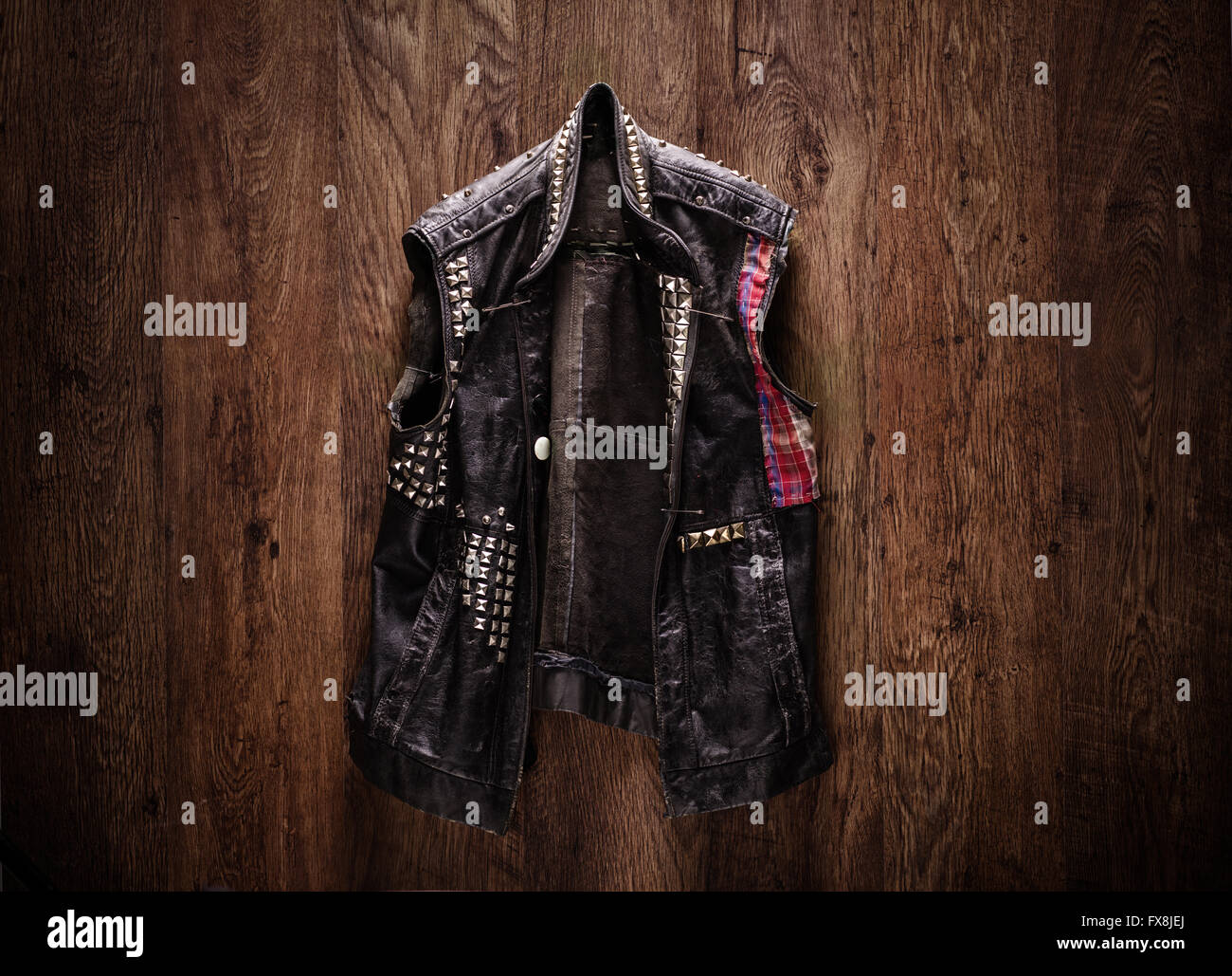 De la vieja escuela punk-rock chaqueta de cuero colgado sobre un fondo de  madera Fotografía de stock - Alamy