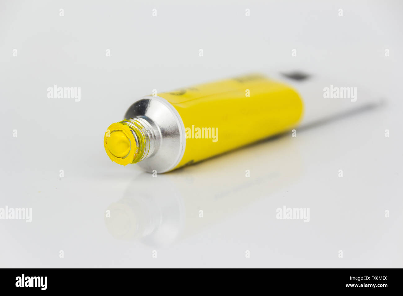 La pintura de color amarillo, tubo, tubo macro sobre fondo blanco. Foto de stock