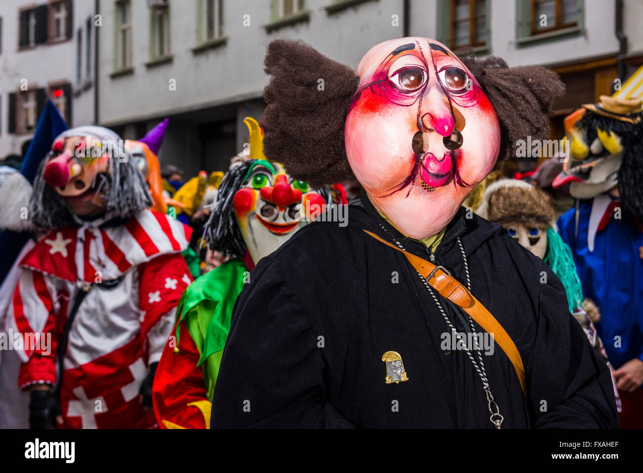 Muchos grupos diferentes de gente enmascarada caminando por las calles de la ciudad de Basilea, 3 días y noches, Basler Fasnacht, tocando música Foto de stock