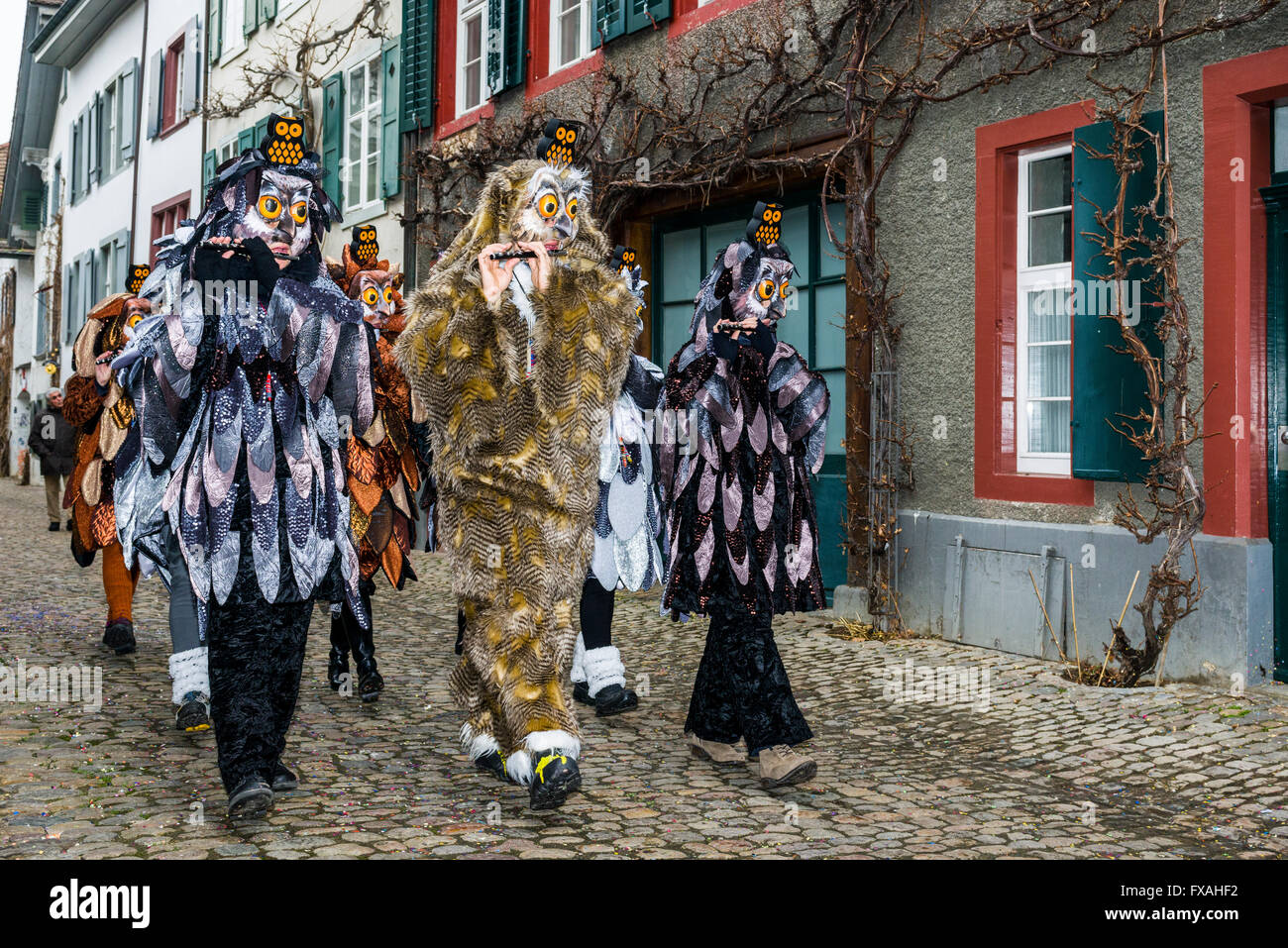 Muchos grupos diferentes de gente enmascarada caminando por las calles de la ciudad de Basilea, 3 días y noches, Basler Fasnacht, tocando música Foto de stock