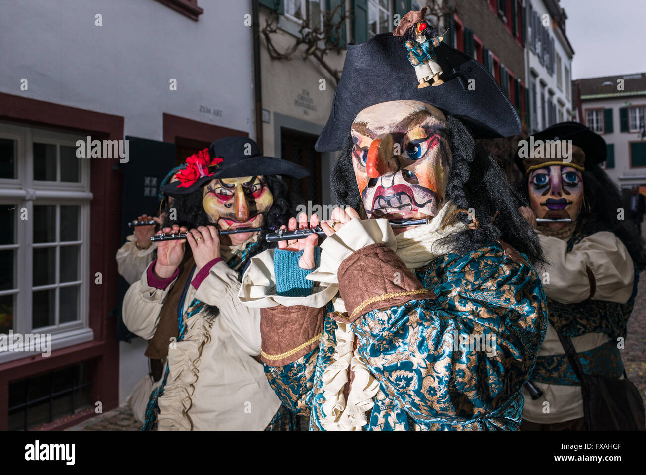 Muchos grupos diferentes de gente enmascarada caminando por las calles de la ciudad de Basilea, 3 días y noches, Basler Fasnacht, tocando música Foto de stock