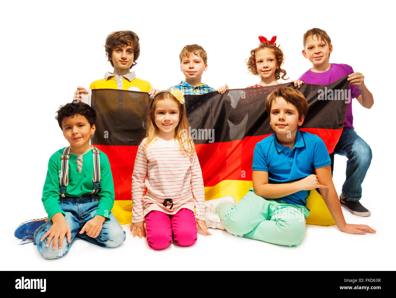 Grupo de siete niños sentados con la bandera alemana Foto de stock