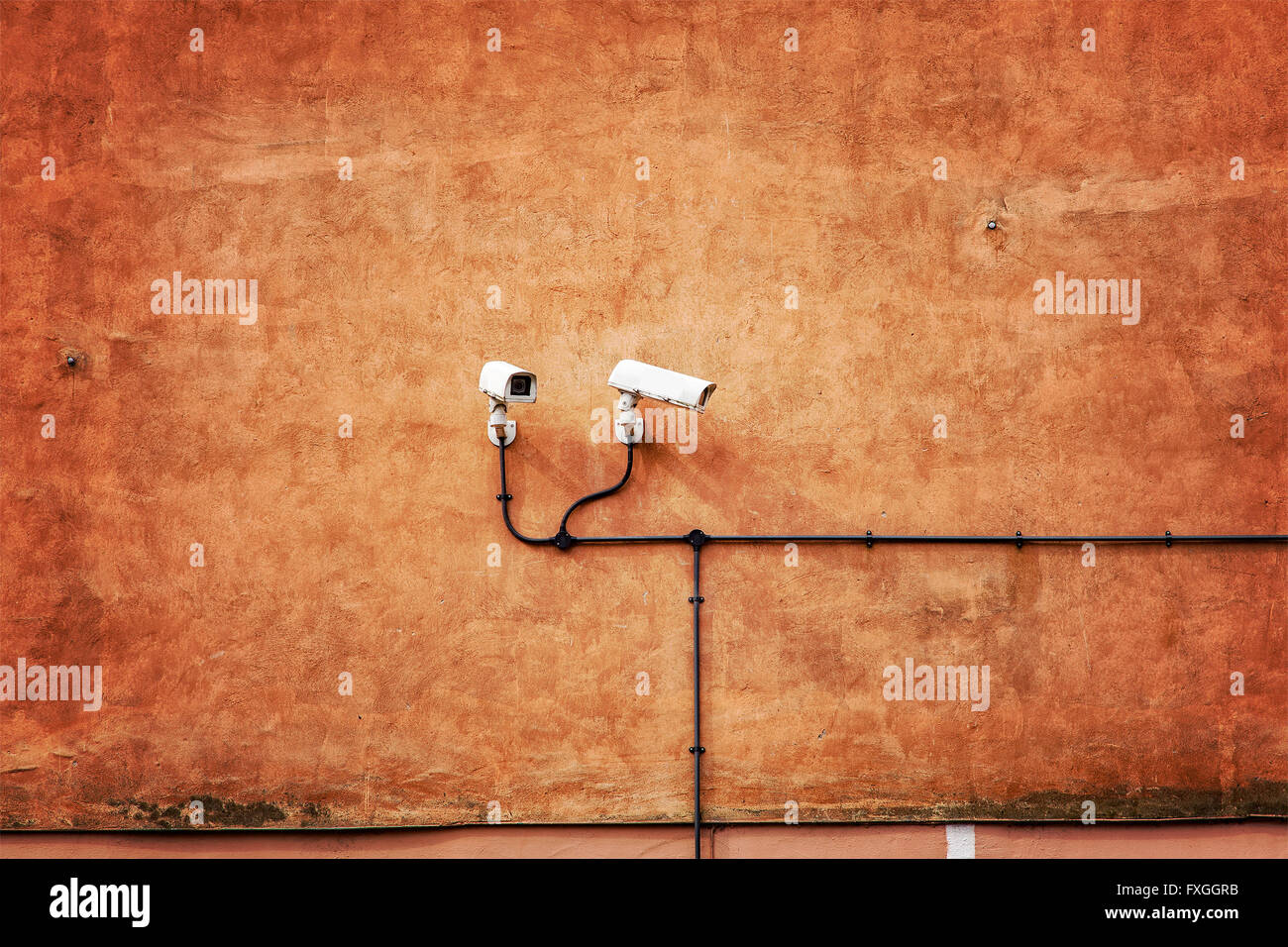 Imagen de cámaras de seguridad en el muro de color naranja. Foto de stock