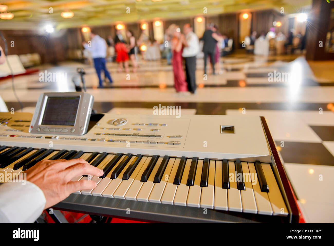 Hombre que jugando en un piano electrónico en restaurante. Foto de stock