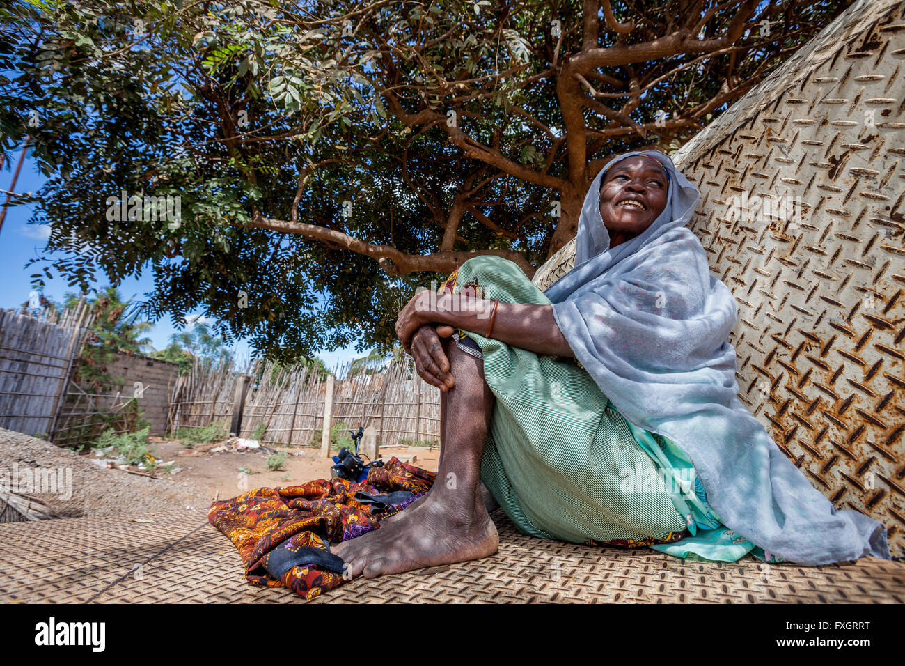 Mozambique, una anciana está sentado bajo un árbol para descansar. Foto de stock