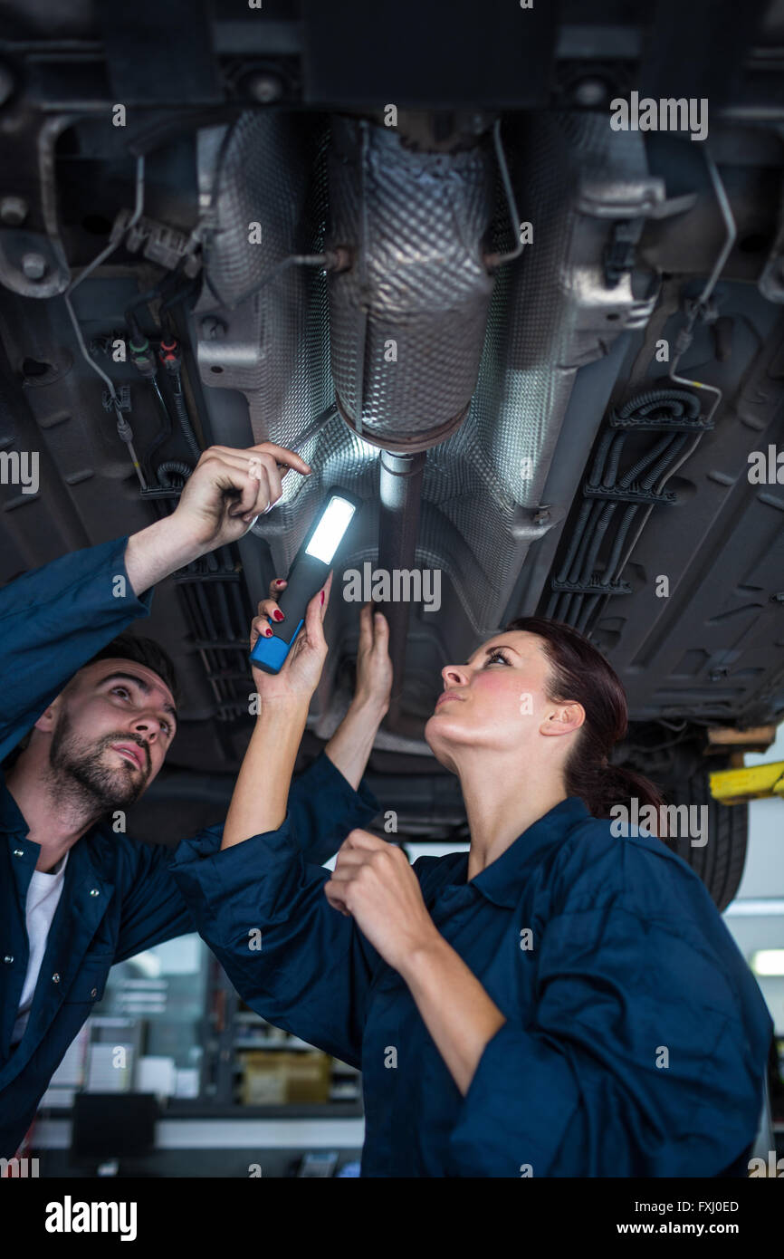 mecánico masculino sostiene una linterna para examinar el automóvil 1226502  Foto de stock en Vecteezy