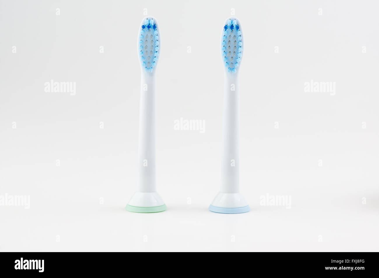 Dos accesorios para cepillo de dientes eléctrico sobre un fondo blanco. Foto de stock