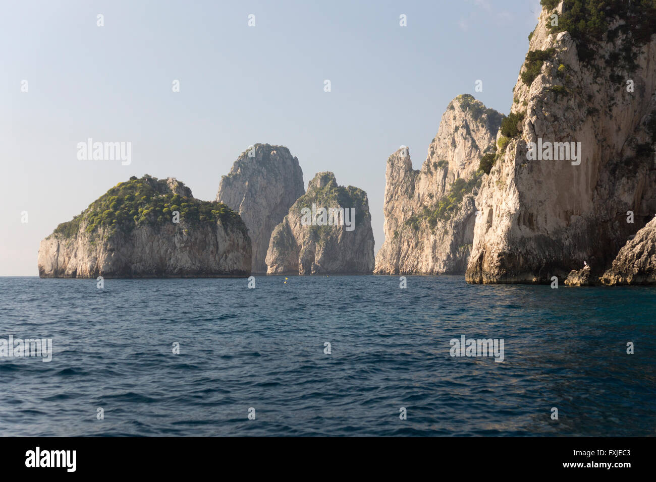 Las rocas Faraglioni, Stella, di Mezzo y di Fuori frente a la costa sur de Capri. El legendario trío de gigantes marinos de Capri en el Golfo de Nápoles. Italia Foto de stock