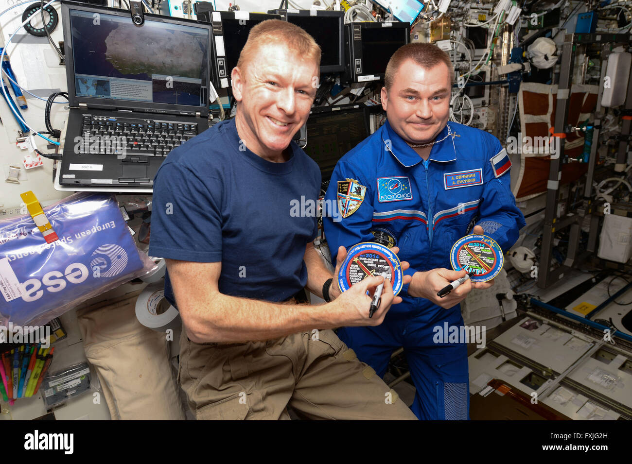 Estación Espacial Internacional la expedición 47 tripulantes astronauta británico Tim Peake, izquierda, y el cosmonauta ruso Alexey Ovchinin cruzar sus nombres fuera de la ceremonia de la "Liga de los astronautas Unflown' parche 9 de abril de 2016 en la órbita de la tierra. Ambos se encuentran en su primer vuelo espacial y la 221st y 222ª personas para visitar la Estación Espacial Internacional desde su creación. Foto de stock