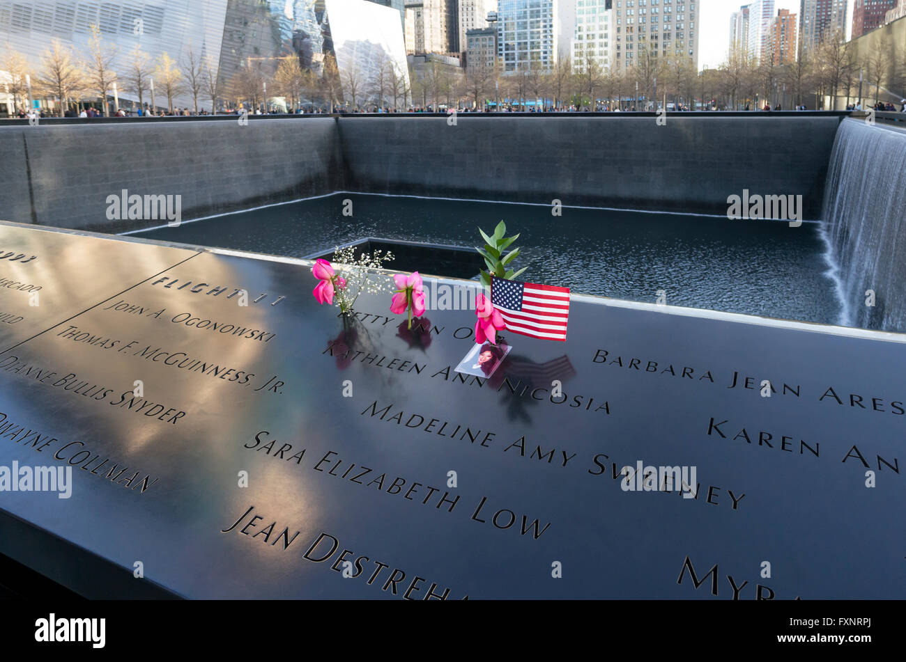 La piscina del norte del World Trade Center, con rosas, una bandera y una instantánea de uno de los caídos Foto de stock