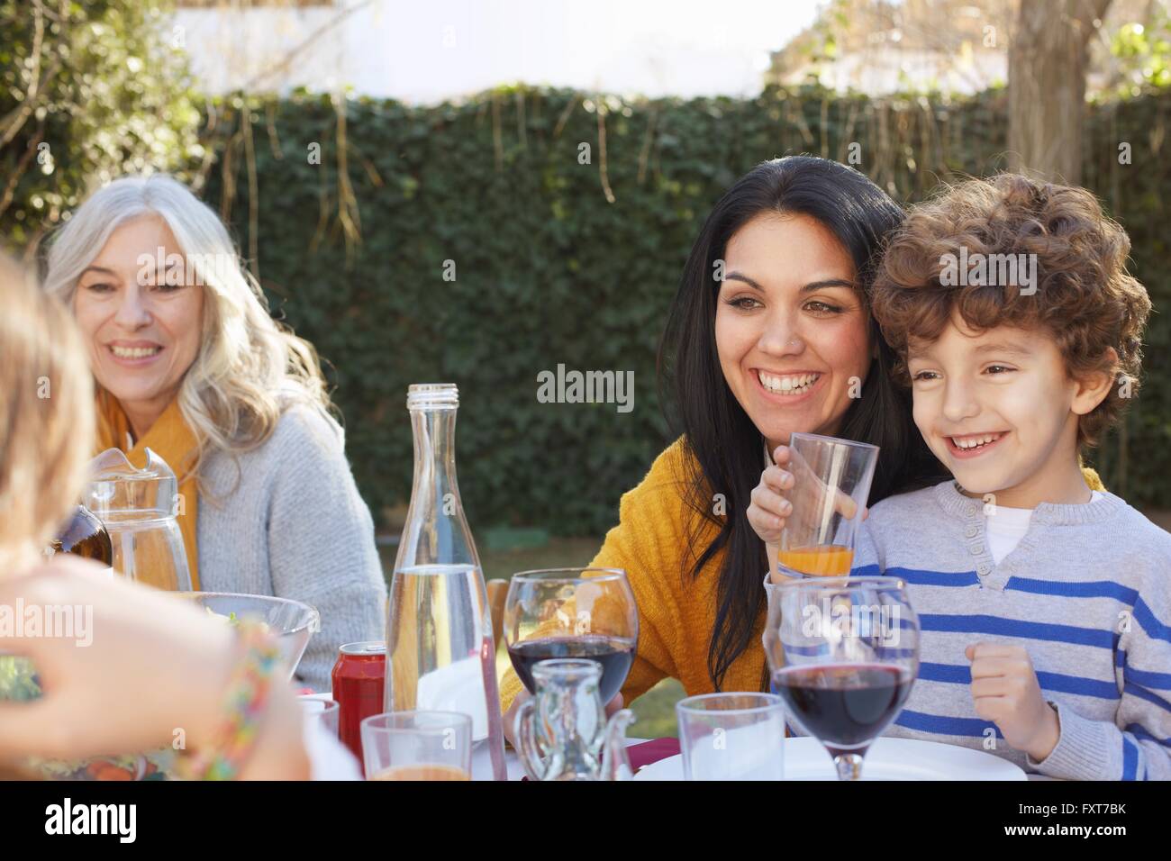 Generación de múltiples cenas familiares en el exterior, sonriendo Foto de stock