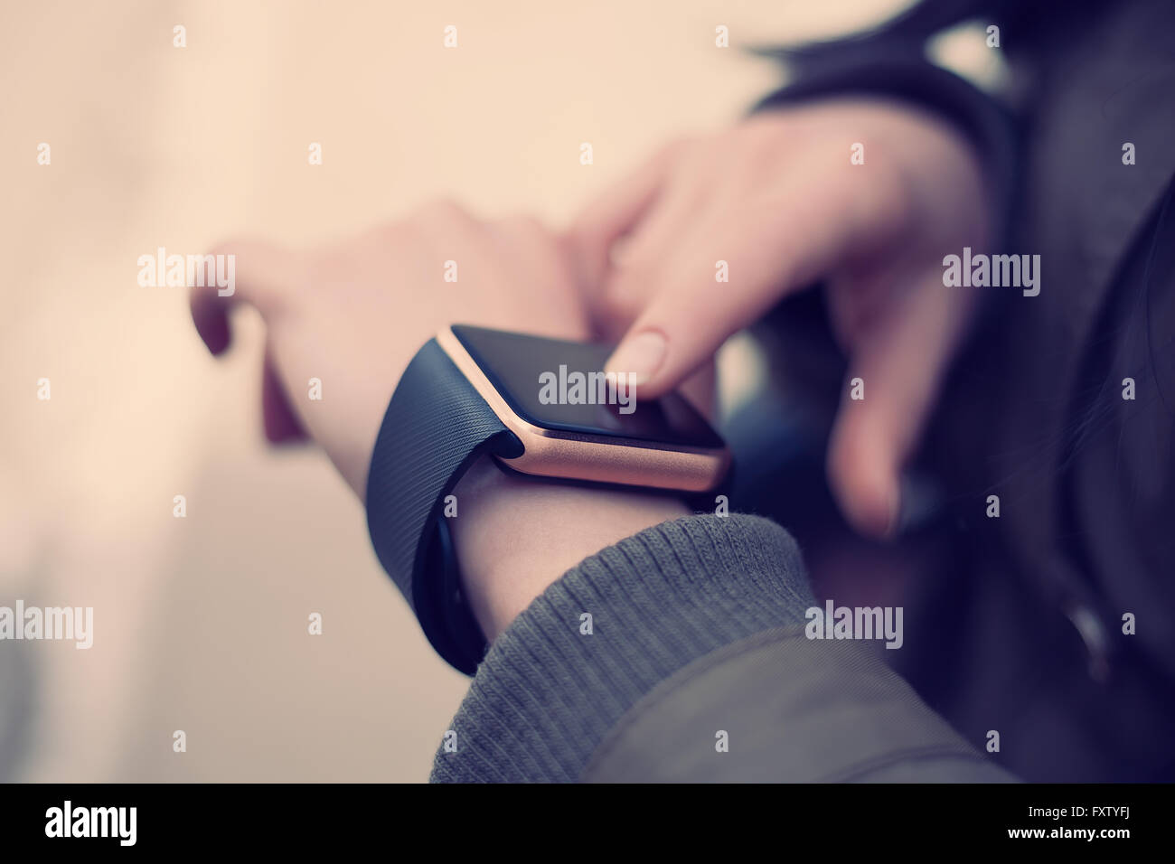 Manos femeninas touchgin su reloj de pulsera inteligente de moda. Este nuevo gadget te permite estar siempre conectado a internet y a las redes de medios de comunicación social desde cualquier lugar que desee. Foto de stock