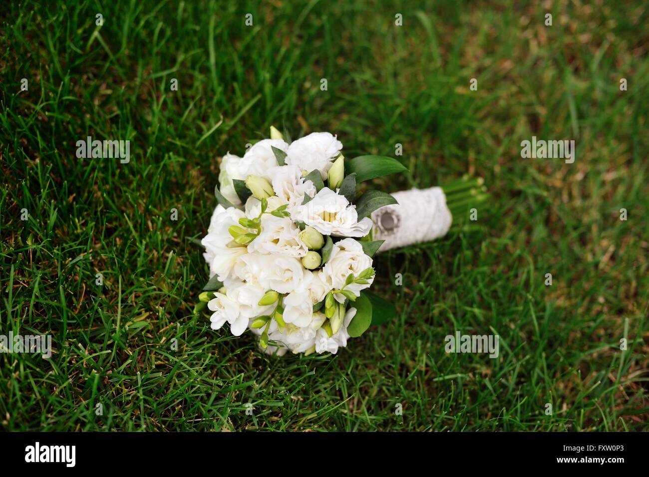 Boda nupcial bouquet blanco sobre la hierba verde Foto de stock
