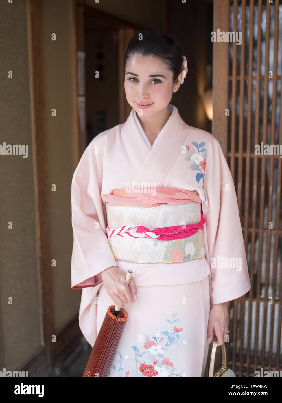 Mujer japonesa vistiendo kimonos pasos fuera de una casa tradicional en Kyoto, Japón Foto de stock
