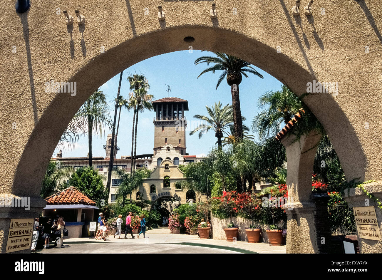 Los huéspedes del hotel y visitantes la cabeza a la entrada de la histórica misión Inn que ha atraído siempre a los presidentes estadounidenses, miembros de la realeza, estrellas de cine y magnates de los negocios a la ciudad de Riverside, en el sur de California, Estados Unidos. Ahora destaca por su arquitectura de estilo renacimiento de la Misión, las lujosas 240 habitaciones y spa comenzó dando la bienvenida a huéspedes en 1876 como una pequeña casa de adobe. La Mission Inn es un estado e histórico nacional y uno de los Hoteles Históricos de América. Foto de stock