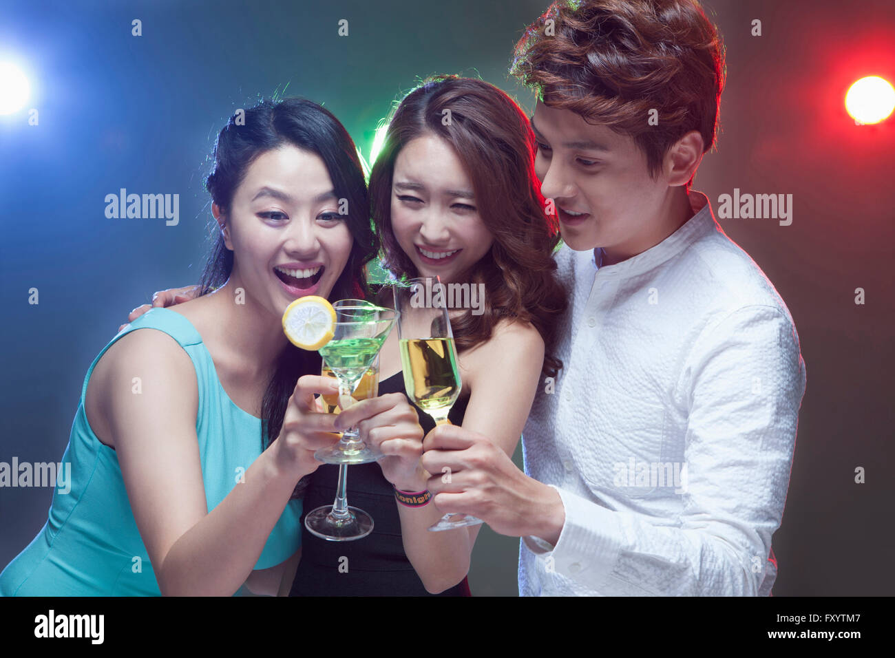 Retrato de tres jóvenes gente sonriente tostar en discoteca Foto de stock